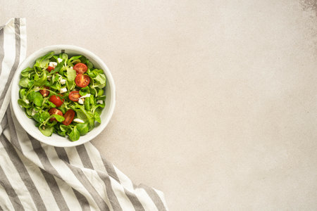 Colorful salad with striped napkin on neutral textured background.の写真素材