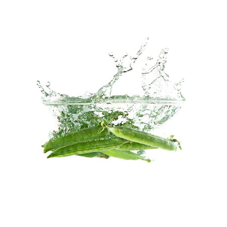 Fresh green peas splash on water. Isolated on white backgroundの写真素材