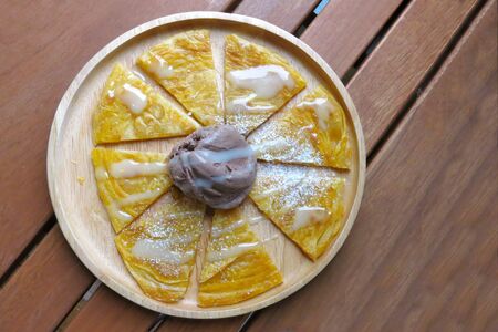 crispy Roti or southern flat bread with a scoop of chocolate flavor ice cream in the plate placing...