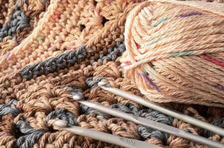 A top view image of crochet yarn, crochet hooks, and hand made granny squares.の写真素材