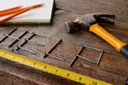 A top view image of the word "help" written out with nails on an old wooden workbench.の写真素材