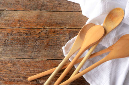 A top view image of several wooden mixing spoons on a white table cloth.の写真素材