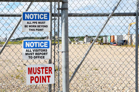 Several notice signs hanging on a chain link fence.