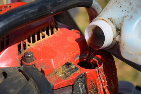 Refueling and old chainsaw.の写真素材