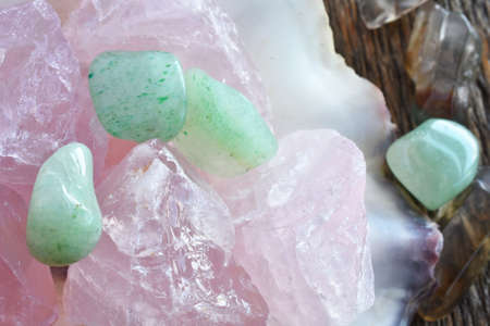 A close up image of rose quartz crystal and green aventurine crystals in an oyster shell.の写真素材