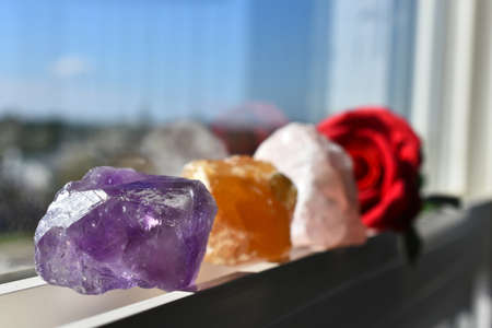 A close up image of three healing crystals charging in the sunlight on a window ledge.の写真素材
