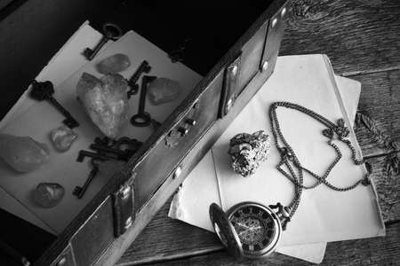 A top view image of an old vintage trunk and pocket watch with citrine crystals and vintage keys.の写真素材