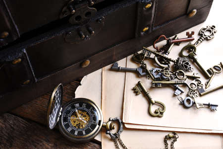 A top view image of an old vintage trunk and pocket watch with citrine crystals and vintage keys.の写真素材
