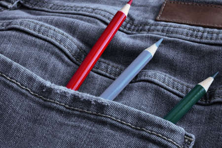 A close up image of three wooden pencil crayons in the back pocket of a pair of denim pants.の写真素材