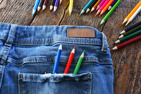 A top view image of several sharpened colored pencils in the pocket of denim jeans.の写真素材