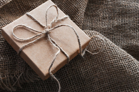 A close up image of a vintage style  brown paper bag and box tied with burlap thread.の写真素材