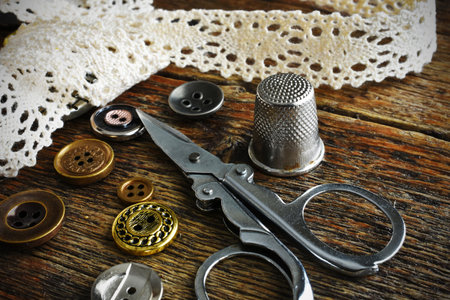 A close up image of vintage sewing items - scissors, lace, and buttons.