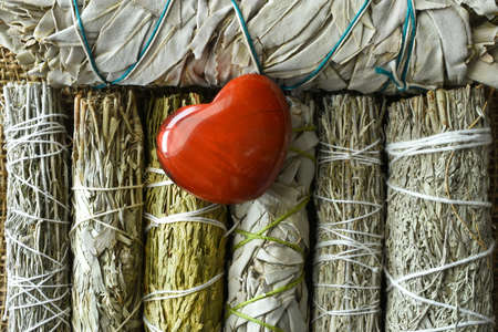 A top view image of white sage bundles with a red jasper heart crystal.の写真素材