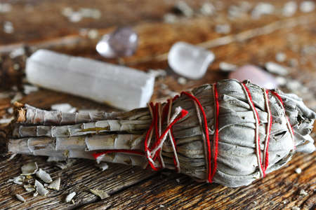A close up image of a white sage smudge stick with selenite wand and healing crystals.の写真素材
