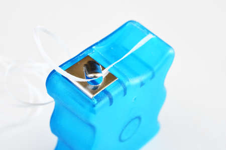 A close up image of a blue dental floss container on a white background.の写真素材