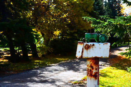 An image of an old rusted metal rural mail box on a metal post.の写真素材
