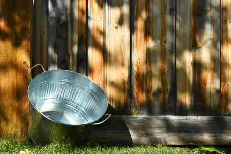 An image of an old metal washtub used for doing laundry.の写真素材