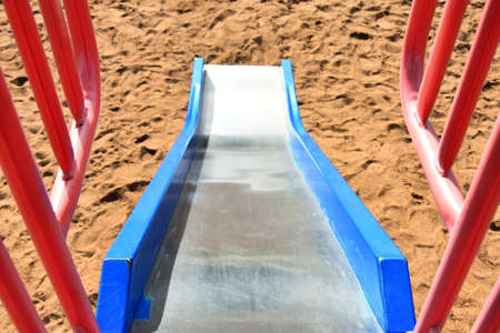 An image of a brightly colored slide on a children's playground.