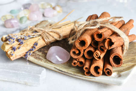A close up image of healing smudge sticks and rose quartz crystals on a hand made pottery plate.の写真素材