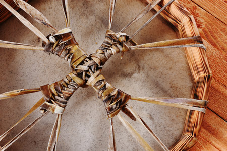 A top view image of the leather lacing of a meditation drum on a wooden table top.の写真素材