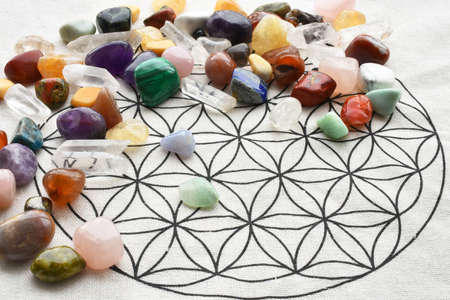 A close up image of a variety of healing crystals with flower of life geometry grid cloth.の写真素材