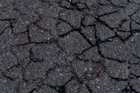 An abstract image of cracked and broken pavement on an old city road.の写真素材