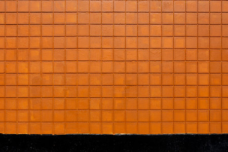 An abstract image of an exterior wall built with orange and black square bricks.の写真素材