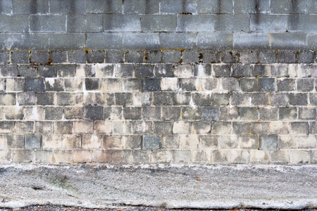 An abstract image of an ancient stone retaining wall with weathered grey and white stones.