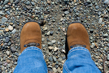An image of a brand new pair of brown ladies hiking boots and a gravel foot path.の写真素材