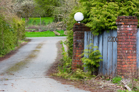 An image of the entrance point of a long gravel driveway.の写真素材