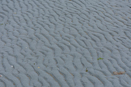 An abstract image of ripple patterns left behind in the sand by the out going tide waters.の写真素材