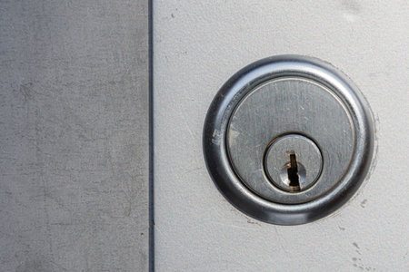A close up image of a scratch newer metal door lock on a steel industrial door.の写真素材