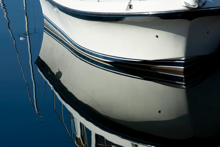 A crystal clear reflection of a boat floating in calm waters while moored in harbor.の写真素材