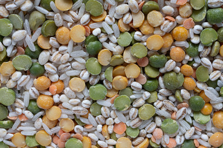 An abstract image dried vegetable soup mix which has rice, barley, peas, and corn.