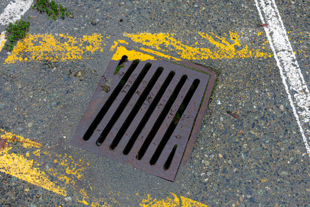 Drainage hatch on the road with yellow line on the groundの写真素材