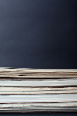 Sheets of paper stacked. Books on a black background. Notebooks. A stack of sketchbooks on a dark...