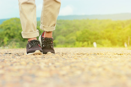 Woman jeans and sneaker shoes walking on the Stone road on the summer season nature on background.の写真素材