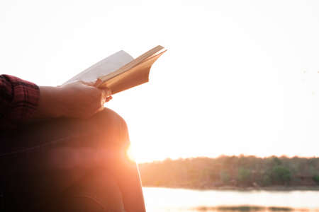 Relaxing moments, Young woman reading a book by the lake. Solo relaxation, color of Hipster Tone.の写真素材