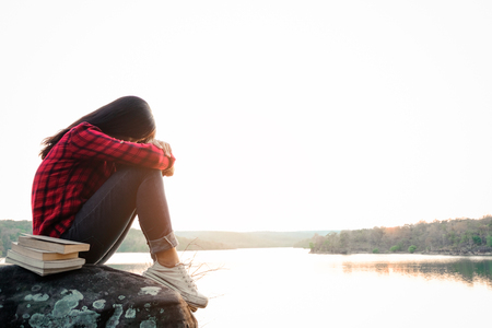 Relaxing moments, Young woman reading a book by the lake. Solo relaxation, color of Hipster Tone.の写真素材