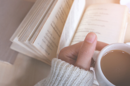 Relaxing moments, Cup of coffee and a book on wooden table in nature background, color of vintage tone and soft focus, winter morning concept.の写真素材