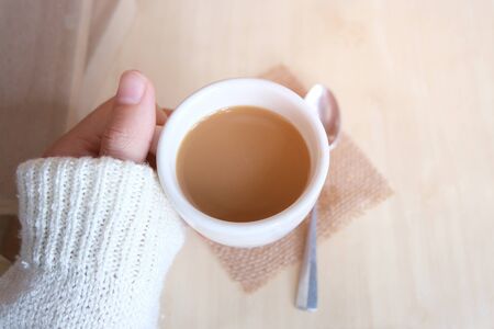 Relaxing moments, Cup of coffee and a book on wooden table in nature background, color of vintage tone and soft focus, winter morning concept.の写真素材