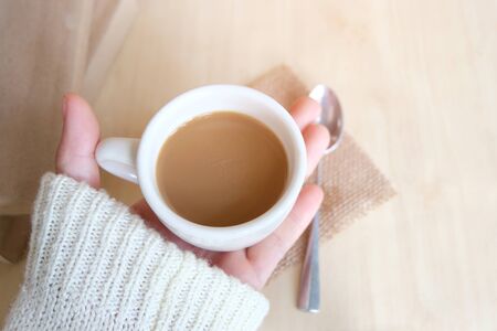 Relaxing moments, Cup of coffee and a book on wooden table in nature background, color of vintage tone and soft focus, winter morning concept.の写真素材