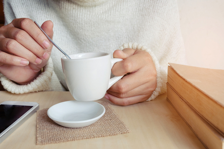 Relaxing moments , Cup of coffee and a book on wooden table in nature background, color of vintage tone and soft focus, winter morning concept.の写真素材