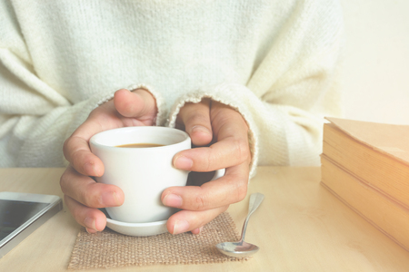 Relaxing moments , Cup of coffee and a book on wooden table in nature background, color of vintage tone and soft focus, winter morning concept.の写真素材