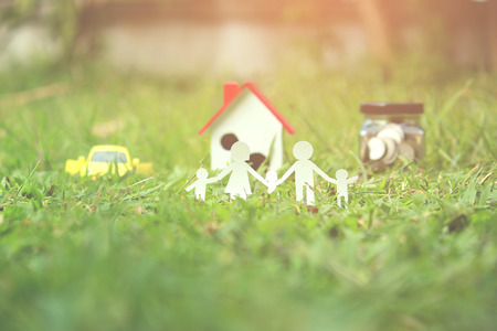 Paper cut of family on green grass, Concepts saving money for House and car, Vintage tone.の写真素材