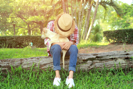 A girl and her dog enjoying travel in nature background  the sunset, color of vintage tone and soft focus.の写真素材