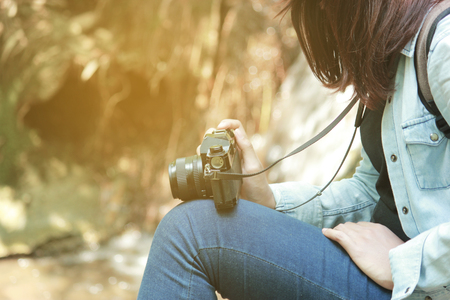 Beautiful woman and camera with backpack in the jungle on the mountain. concept travel, color of vintage tone and soft focus.の写真素材