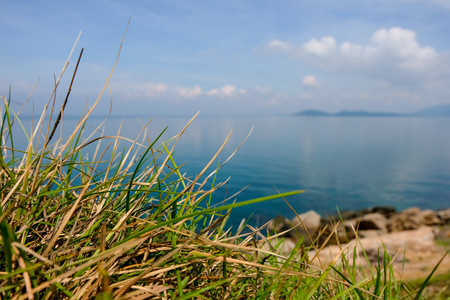 sea horizon with rocky shore cliffs and sun light blue sky background. Sea waves crashing on rocks, Samed, Thailandの写真素材