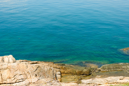 sea horizon with rocky shore cliffs and sun light blue sky background. Sea waves crashing on rocks, Samed, Thailandの写真素材