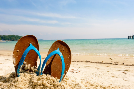 Beach sandals on the sandy sea, Summer concept with sandy beach. Vacation travel icon.の写真素材